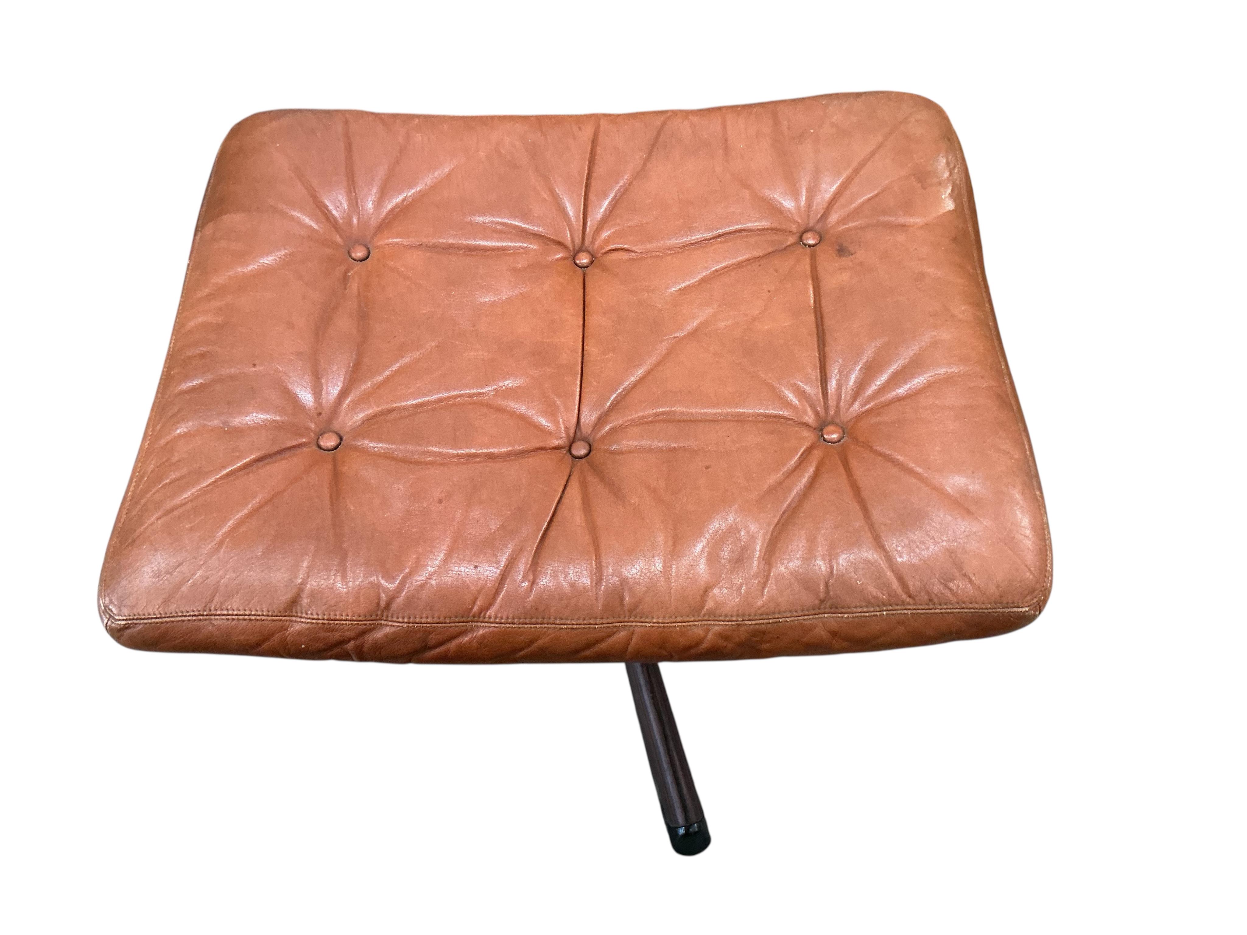 A mid century Swedish Gote Mobler leather swivel chair, width 74cm, depth 80cm, height 86cm and footstool